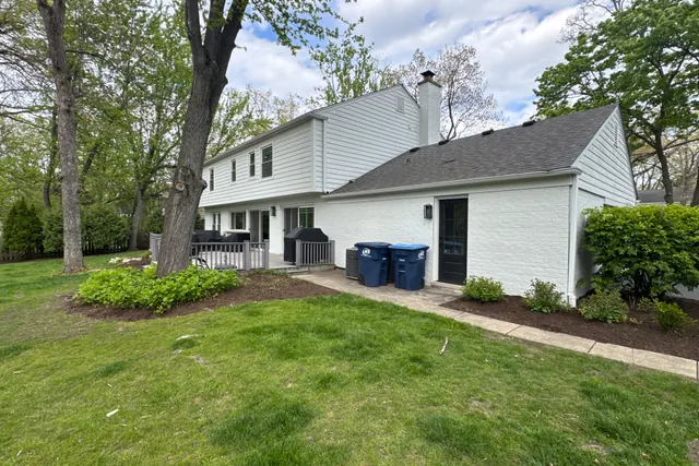 Rear elevation of the house from the lawn with the service walkway and condenser unit