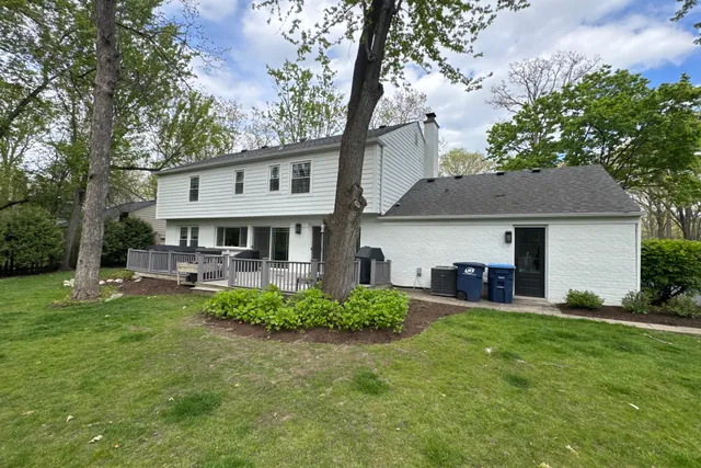 Rear of the house from the far lawn with the mature tree and planting beds